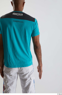 Tiago  1 arm back view blue t shirt dressed…